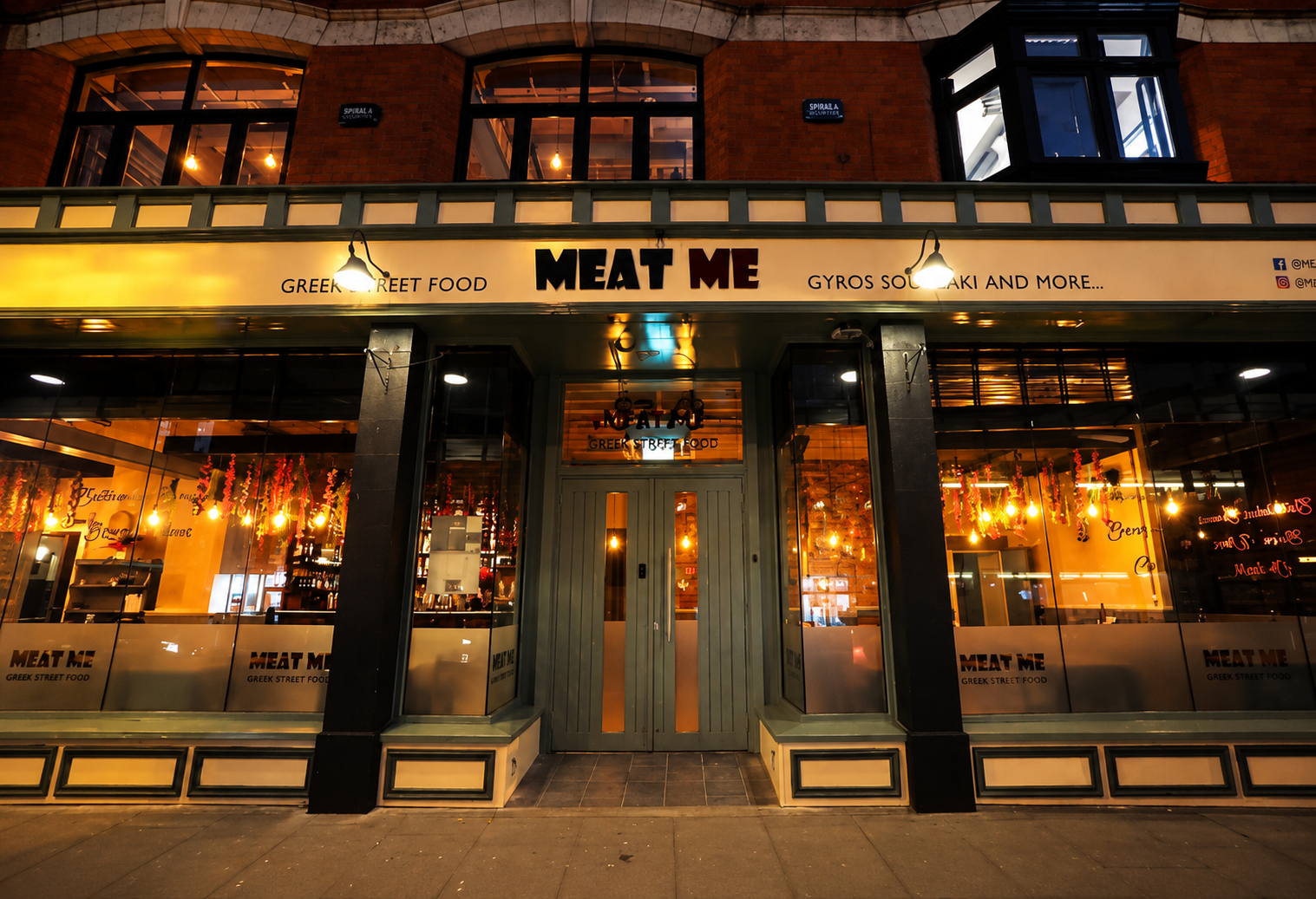 Meat Me Greek Street Food restaurant frontage lit up at night